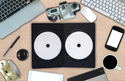 Top view of empty disk with cover and office accessory on paper background, technology equipment mockup, flat lay